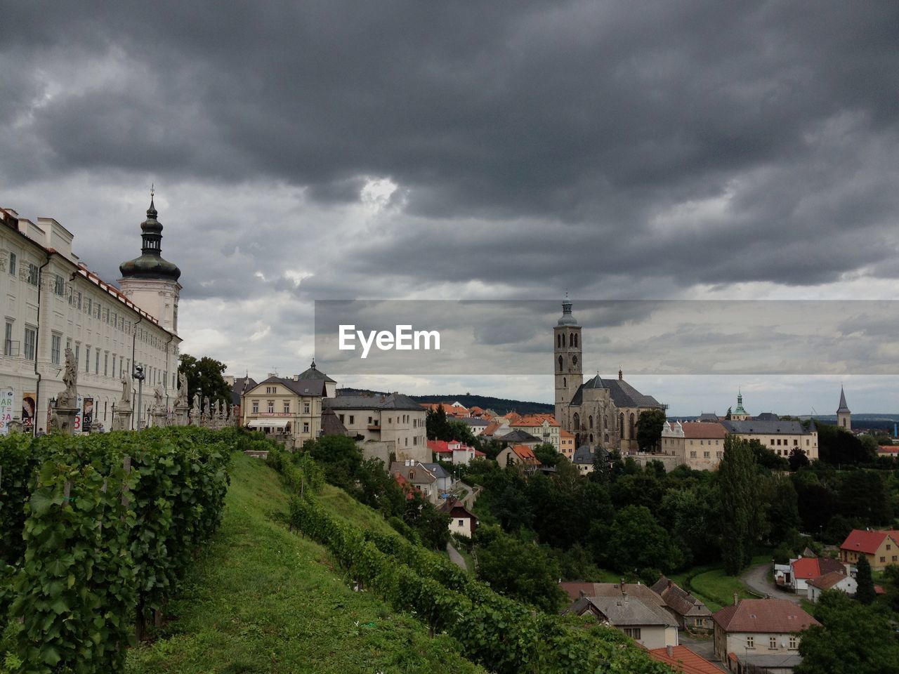 Buildings in town against cloudy sky