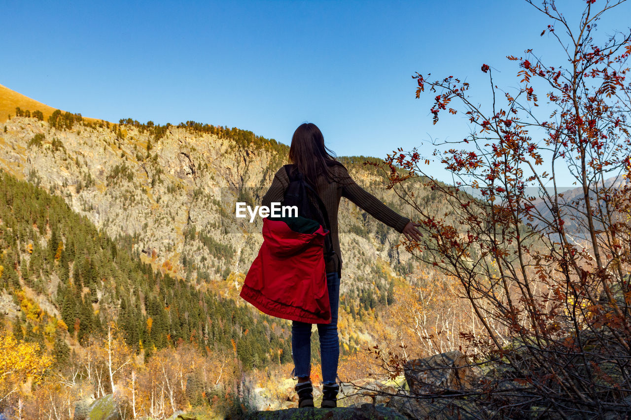 Girl traveler in the background of the mountains