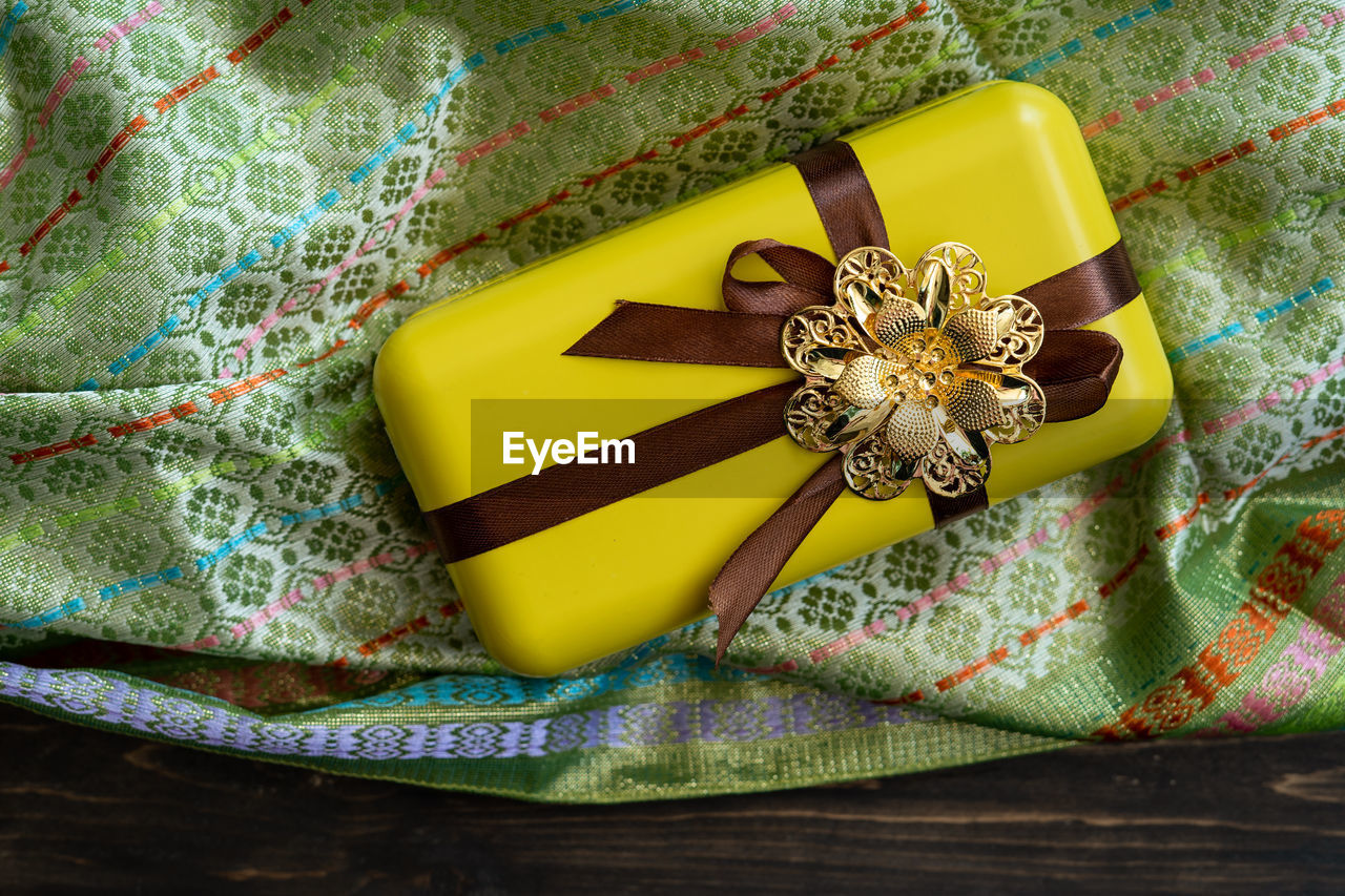 HIGH ANGLE VIEW OF YELLOW FLOWER ON TABLE AT HOME