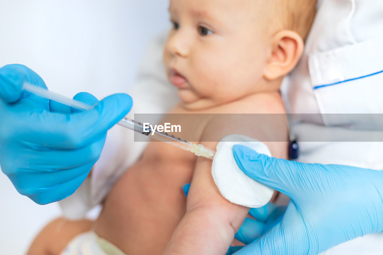 Doctor giving vaccination to baby at clinic