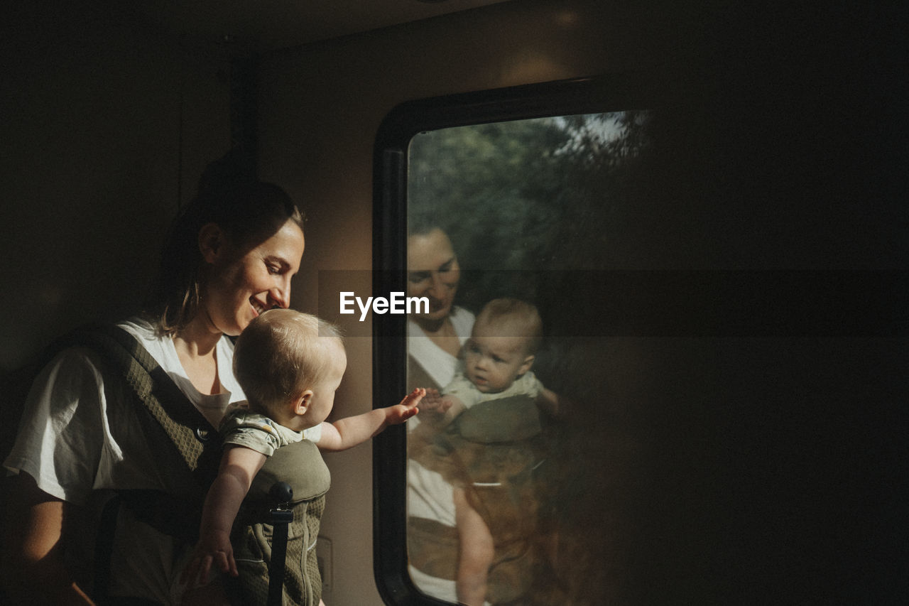 Mother with baby looking through train window