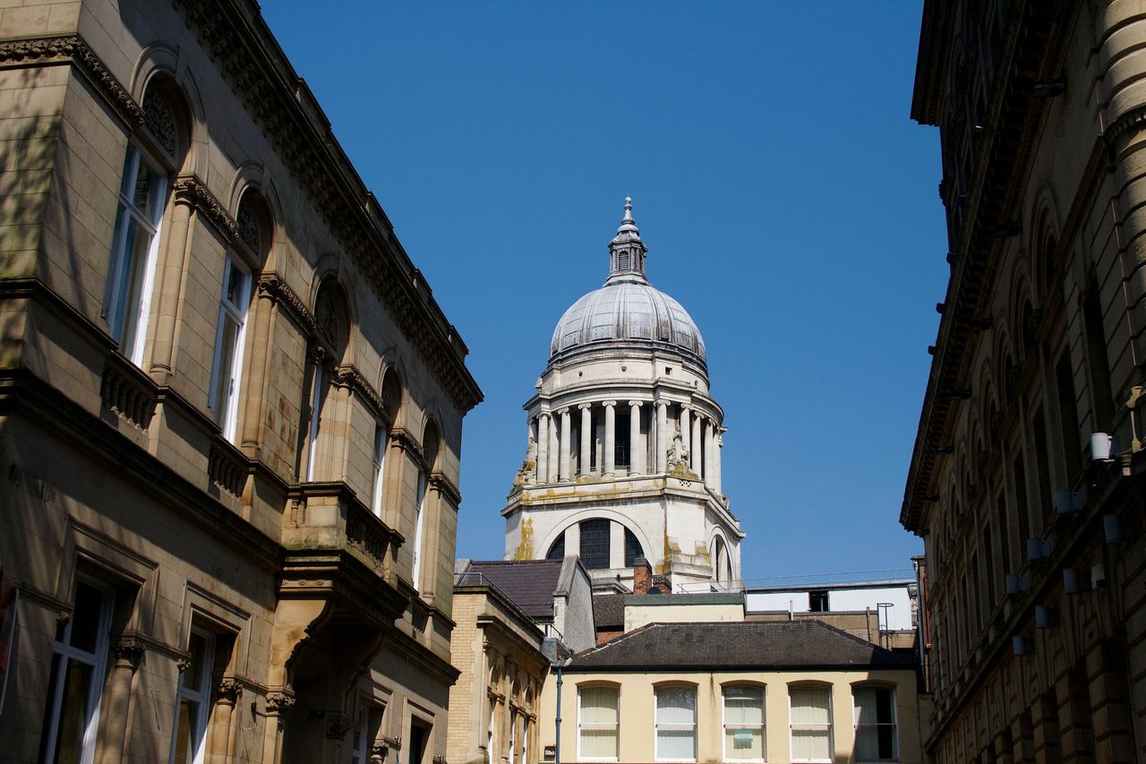 Low angle view of historic buildings against clear blue sky