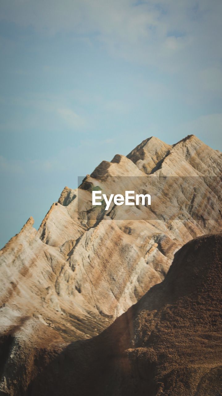 Rock formations on landscape against cloudy sky