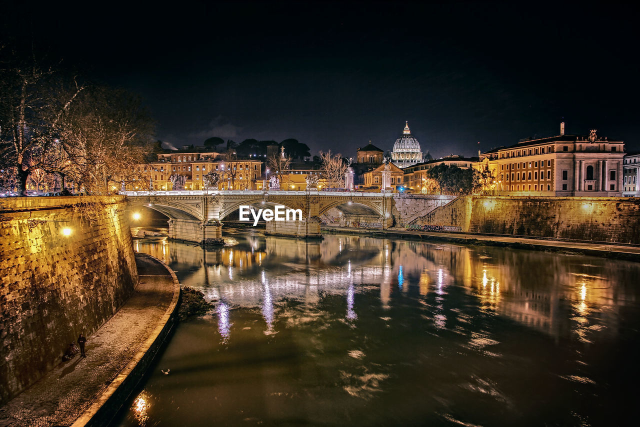 Bridge over river in city at night