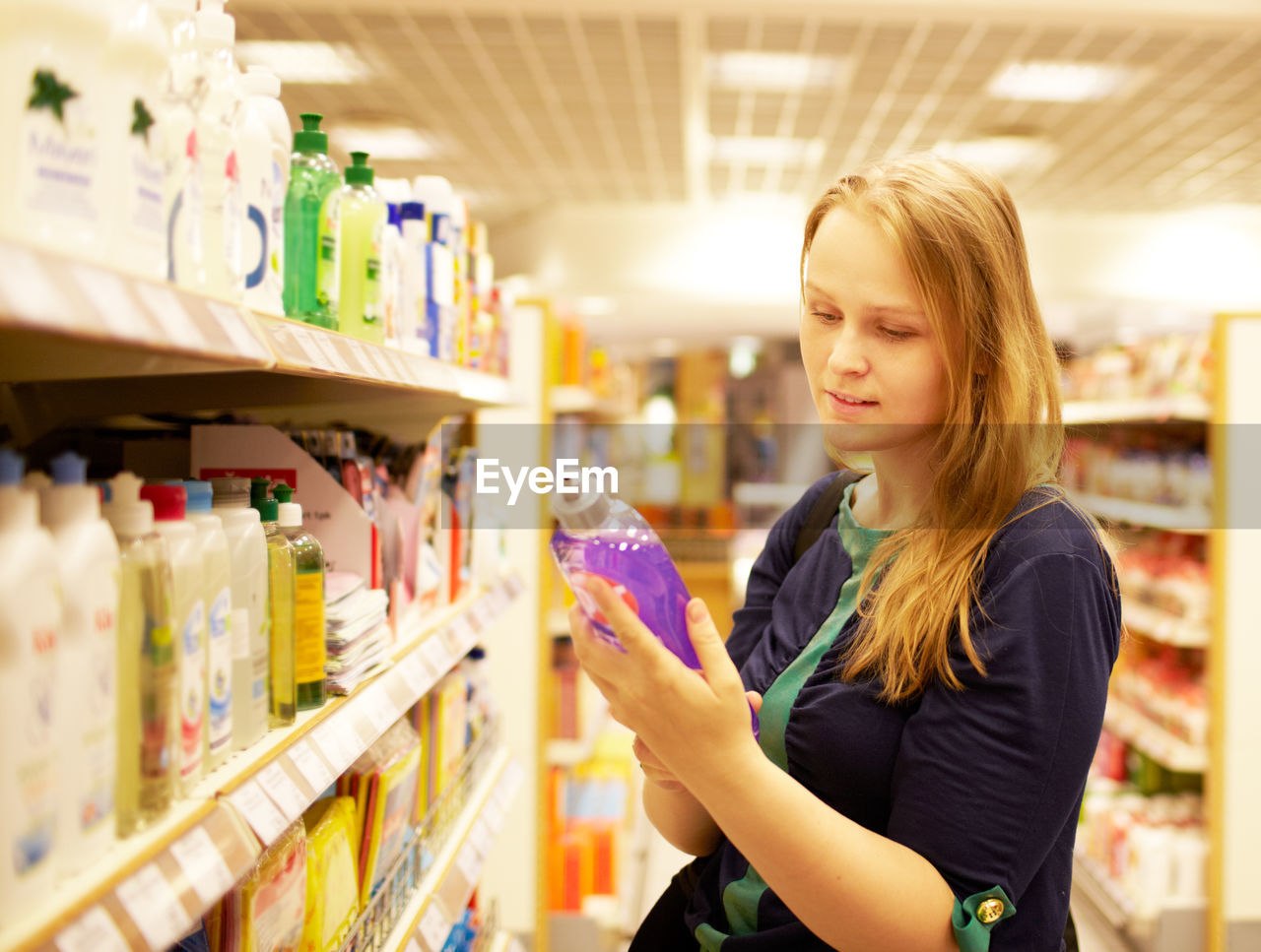 Woman buying soap dispenser in supermarket