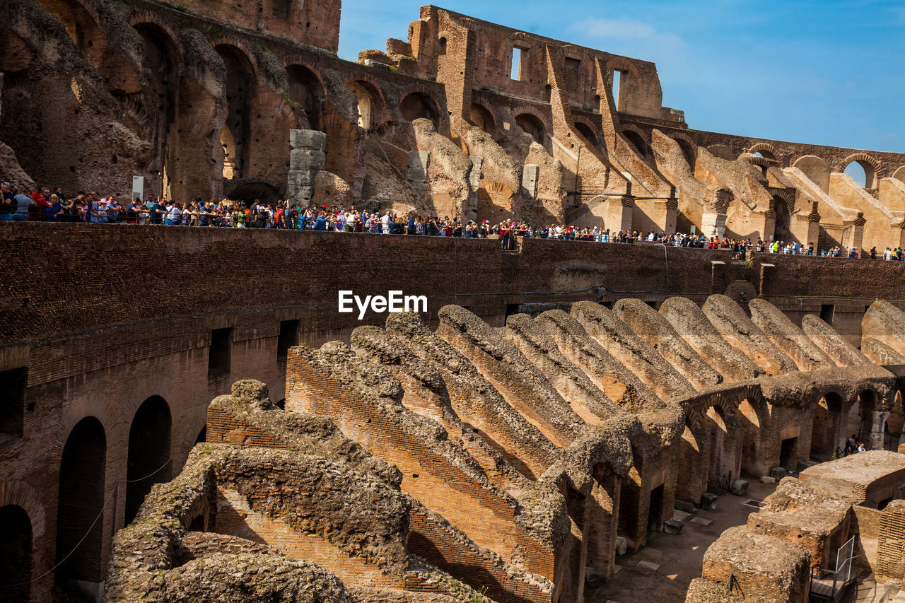 Tourists visiting the interior of the famous colosseum in rome