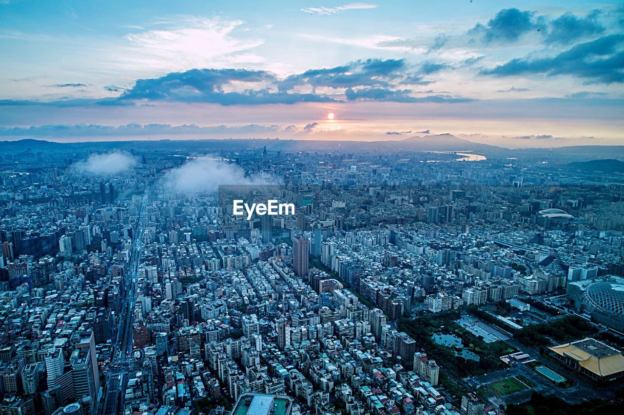 High angle view of modern buildings against sky during sunset