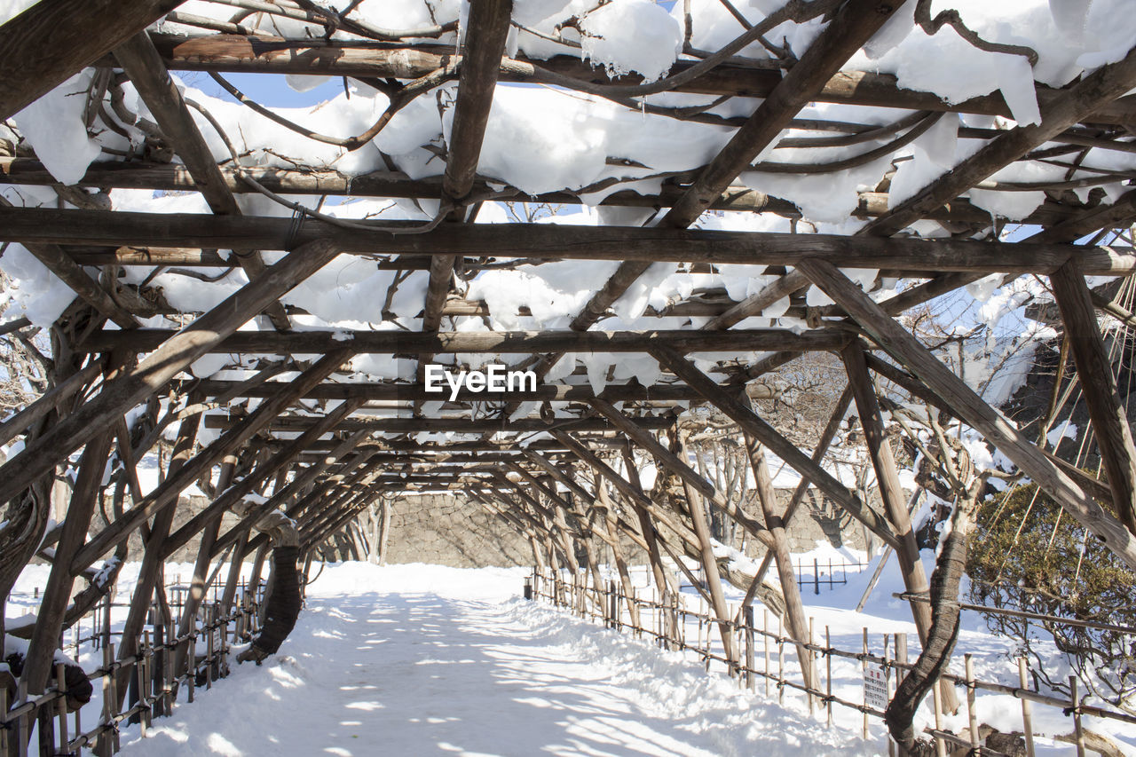 Snow covered wooden structure against sky