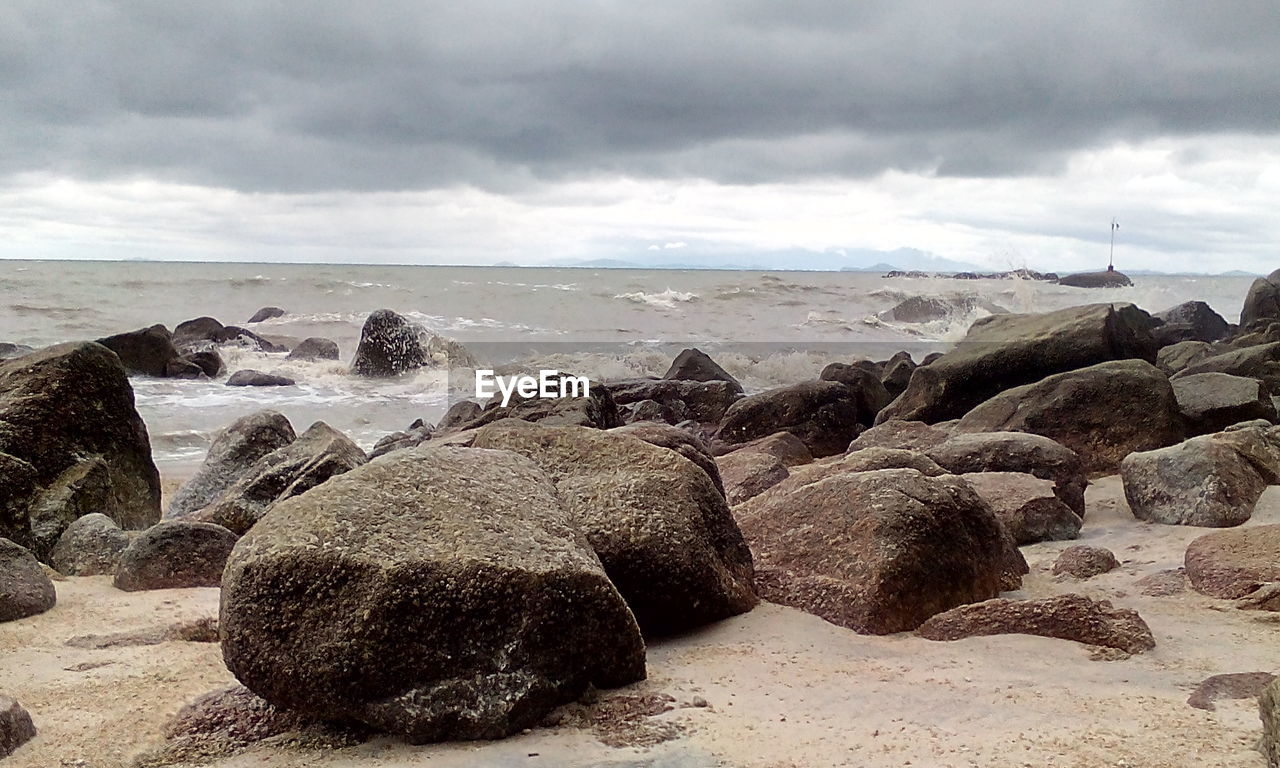 ROCKS ON BEACH AGAINST SKY