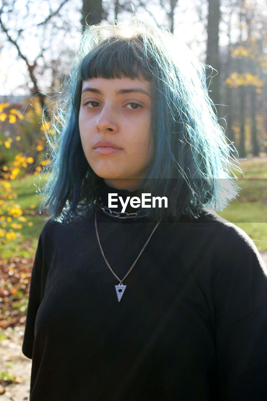 Close-up portrait of young woman with dyed hair at park