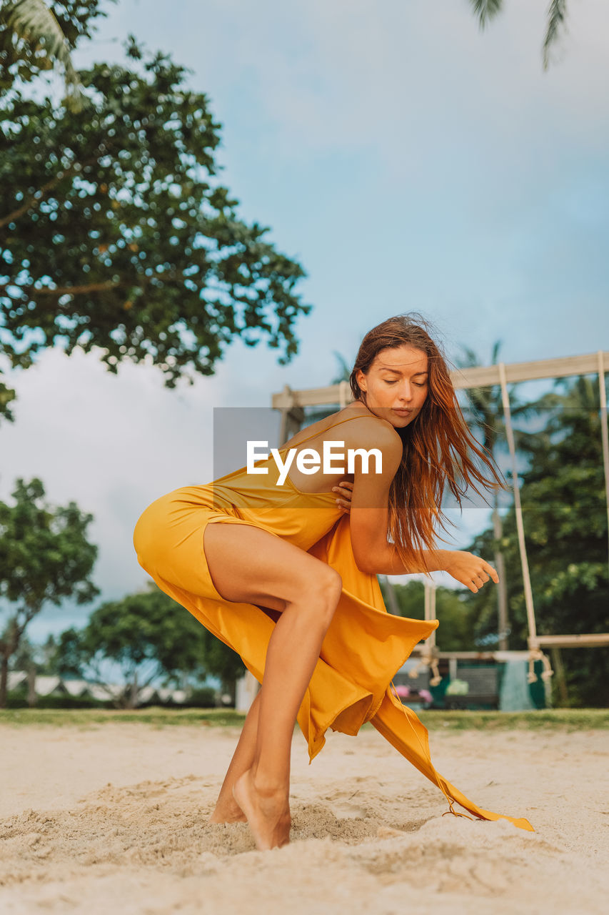 Portrait of young woman dancing on the beach 