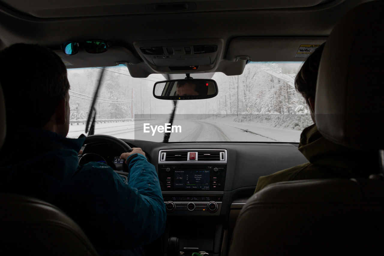 REAR VIEW OF MAN TRAVELING IN CAR