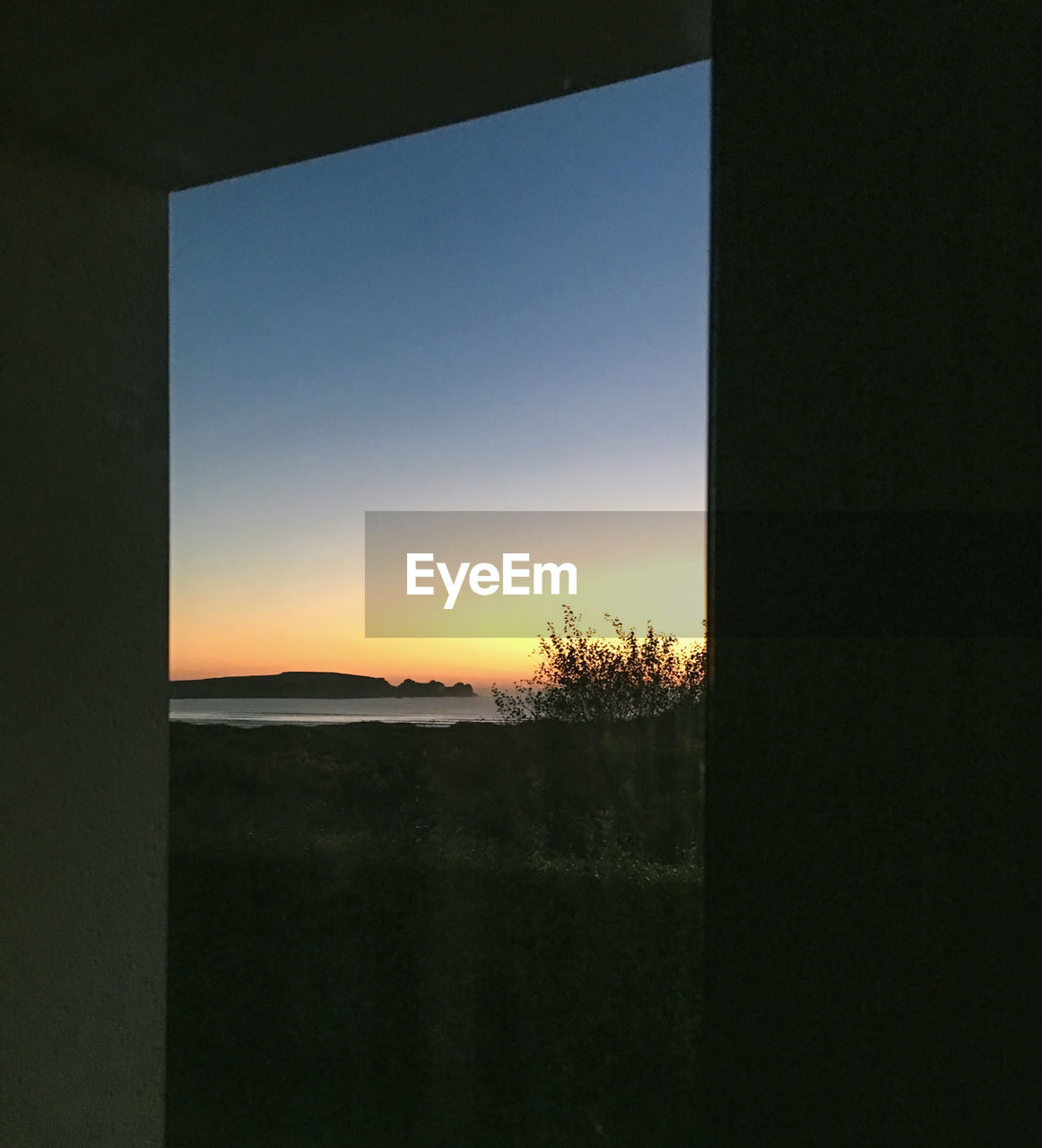 SCENIC VIEW OF SUNSET SEEN THROUGH WINDOW