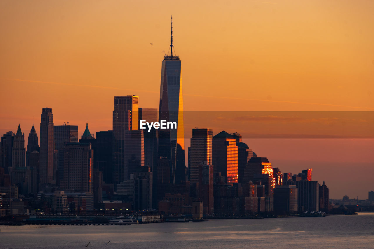 Modern buildings against sky during sunset