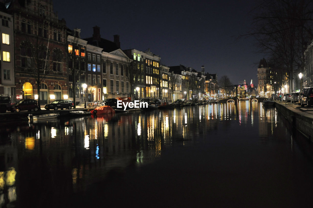 Reflection of illuminated buildings in river at night