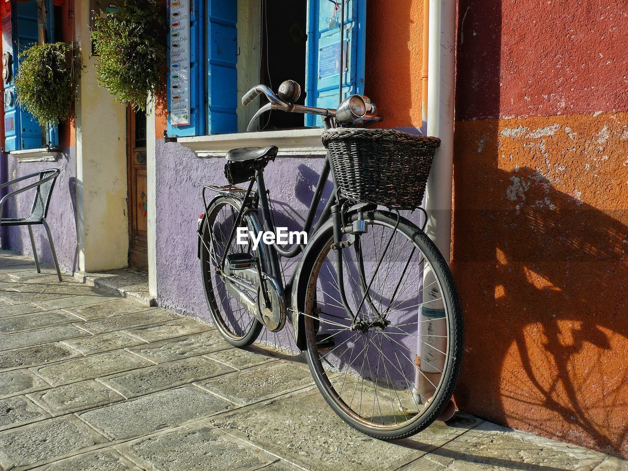 BICYCLE PARKED BY BUILDING