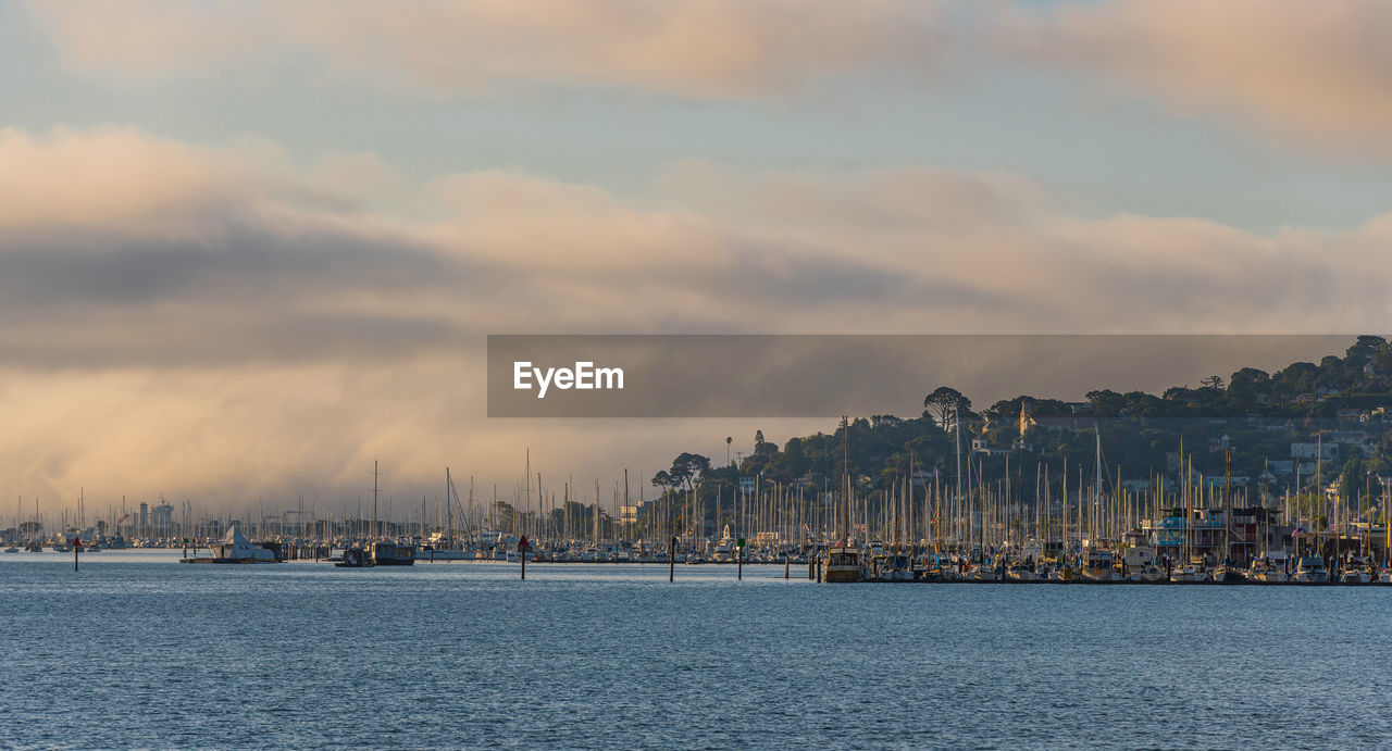Sailboats by sea against sky in city