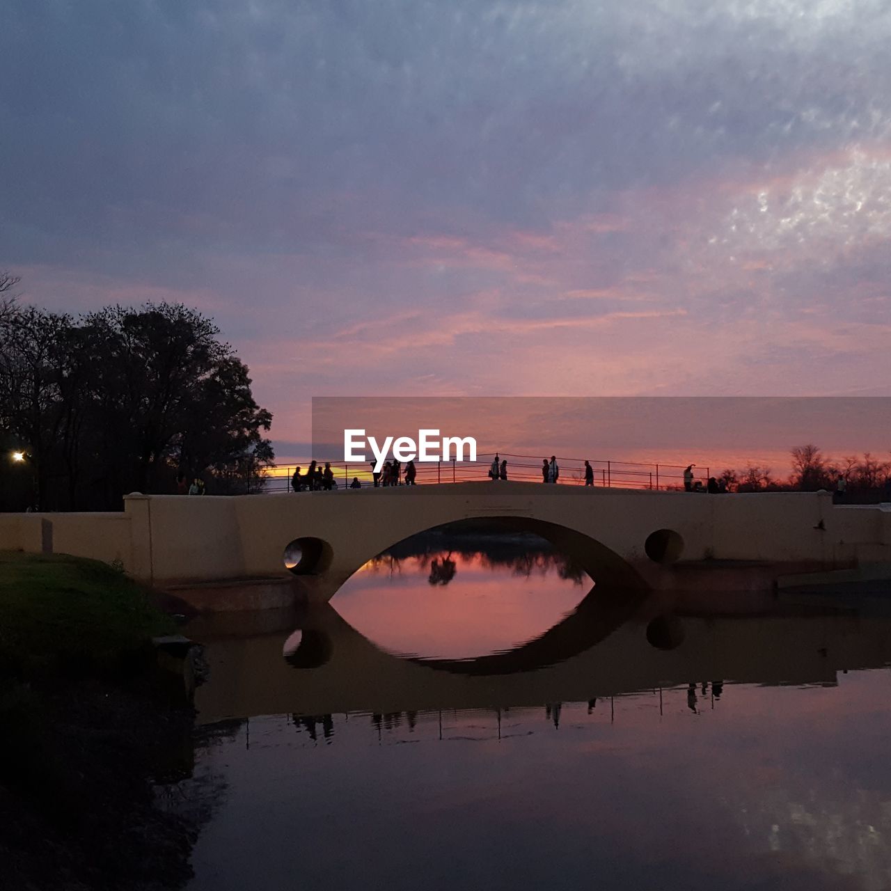 Bridge over river against sky during sunset