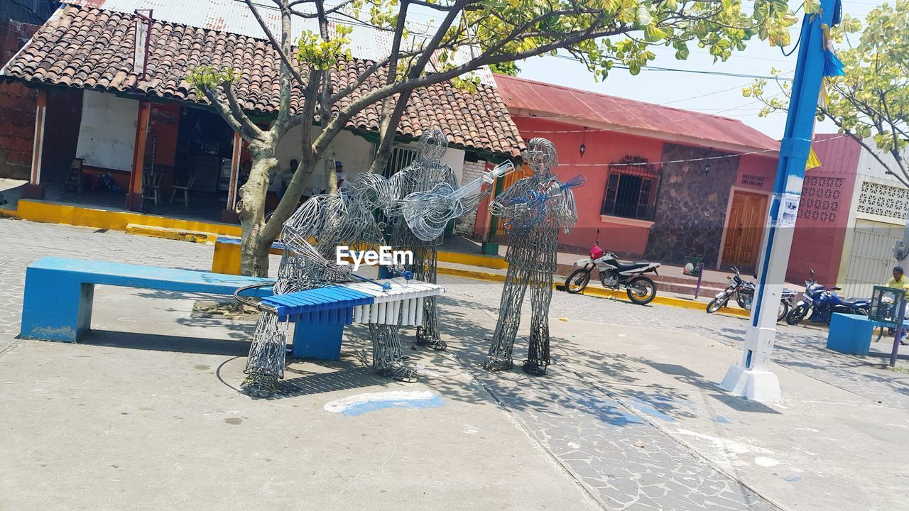 EMPTY BENCH IN PARK AGAINST BUILDING