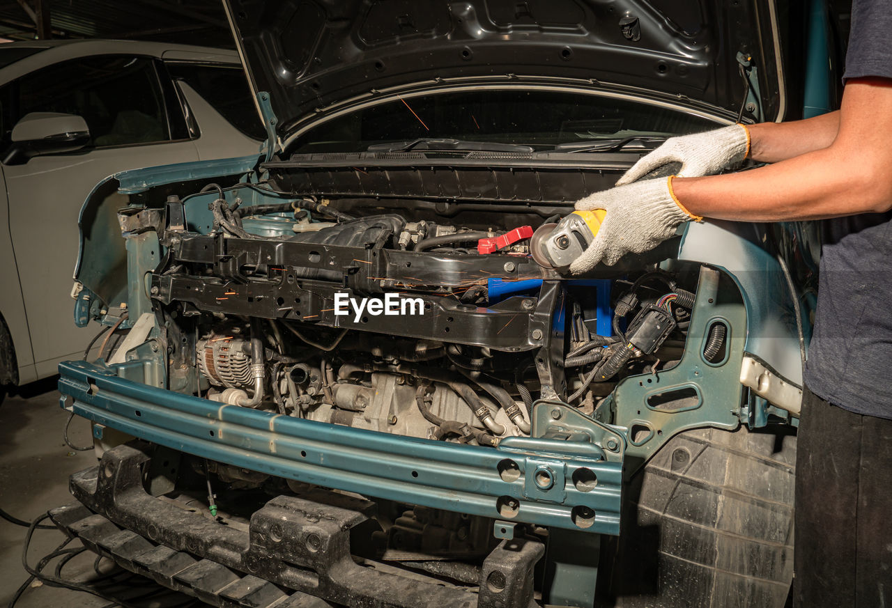 MAN WORKING ON CAR AT MARKET