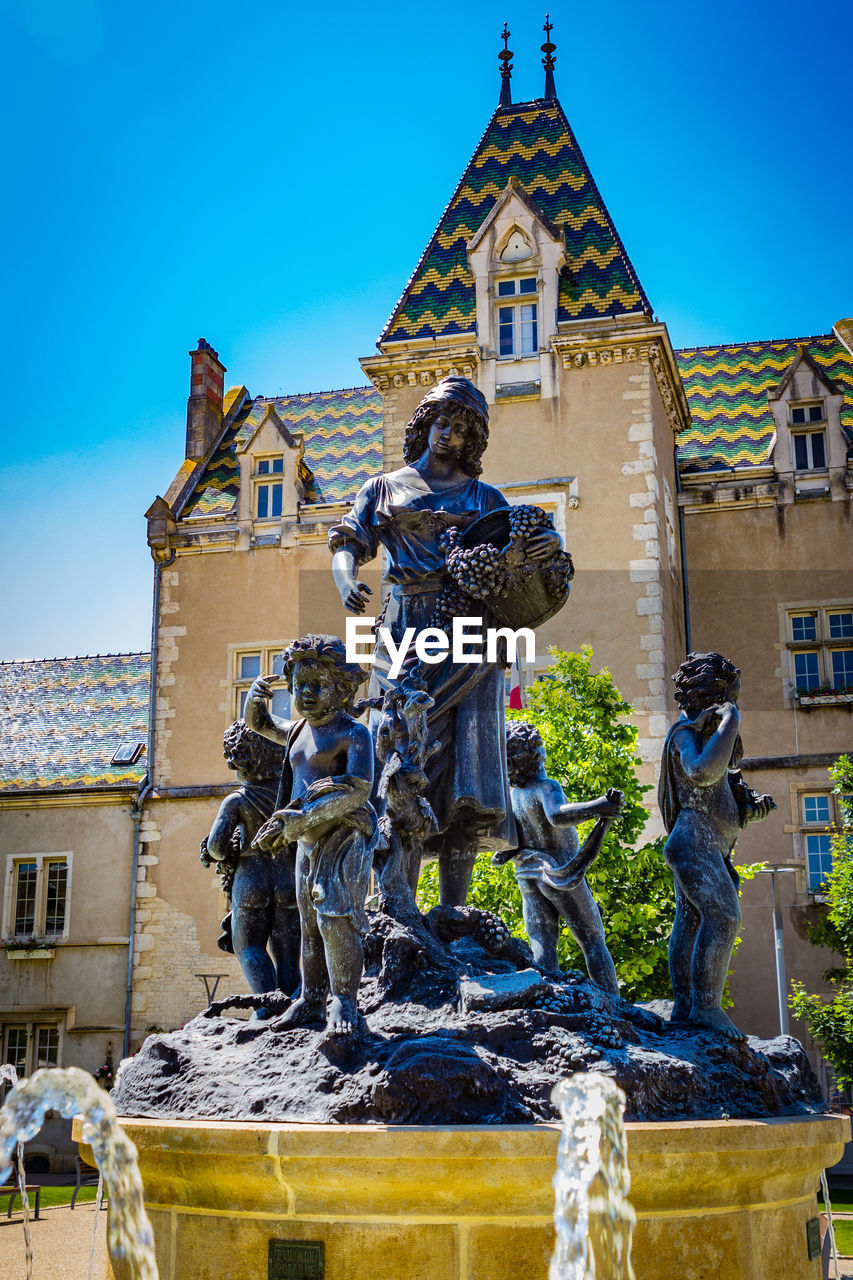 Statue against building against sky