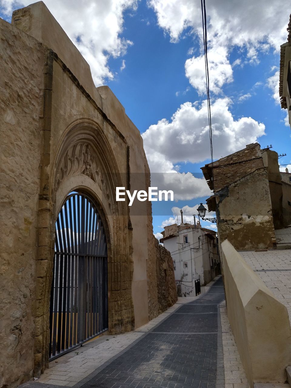 STREET AMIDST BUILDINGS AGAINST SKY