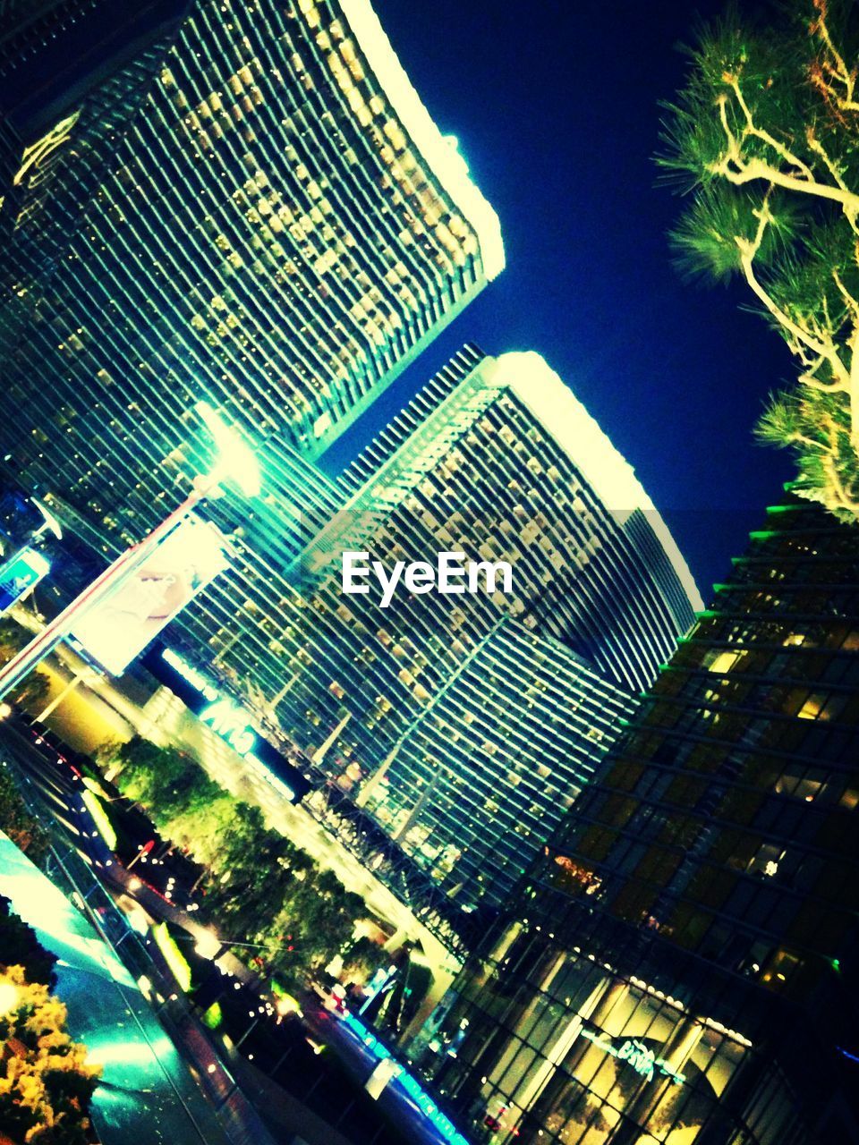 LOW ANGLE VIEW OF MODERN BUILDINGS AGAINST SKY AT DUSK