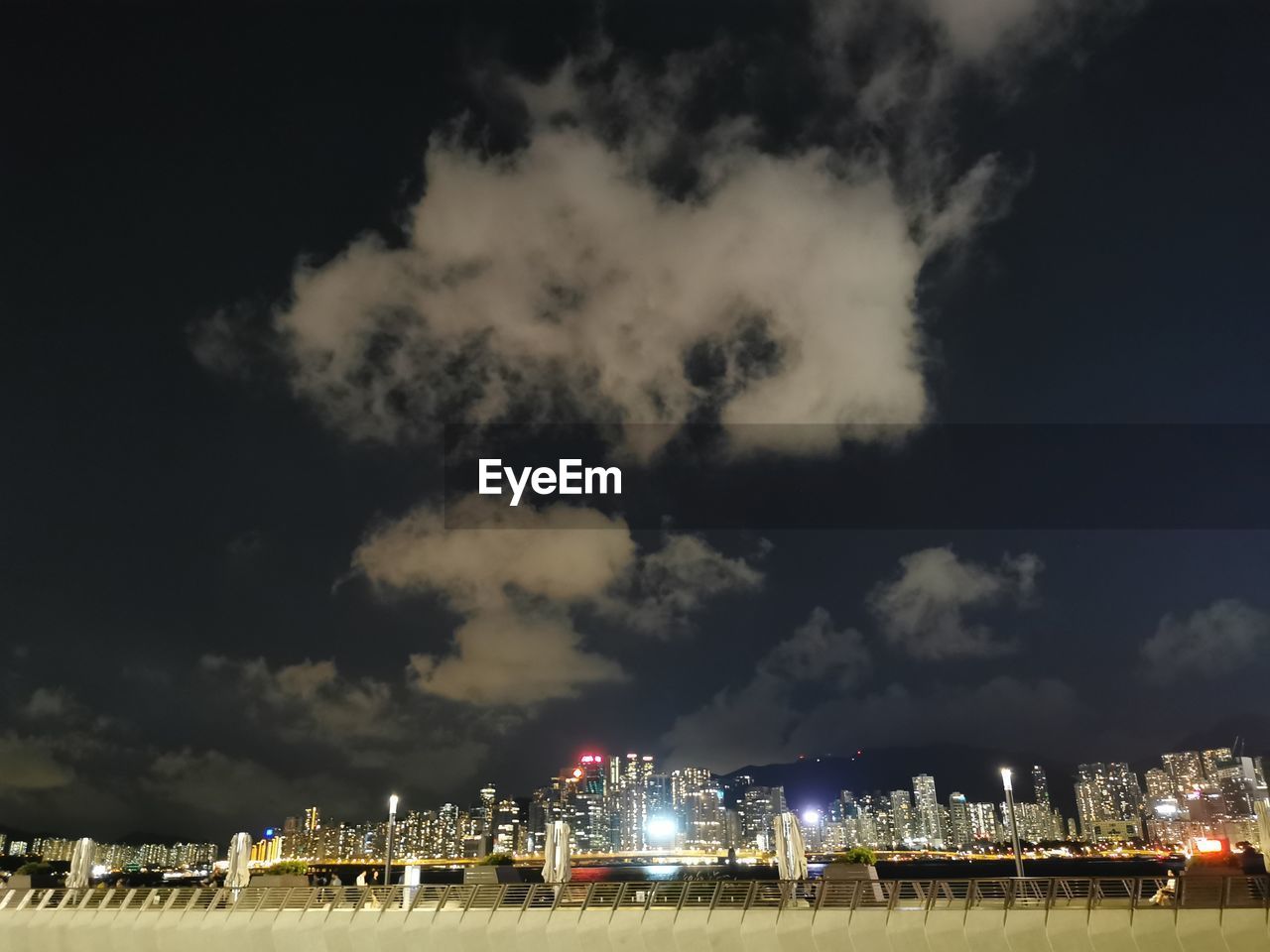 Illuminated city buildings against sky at night