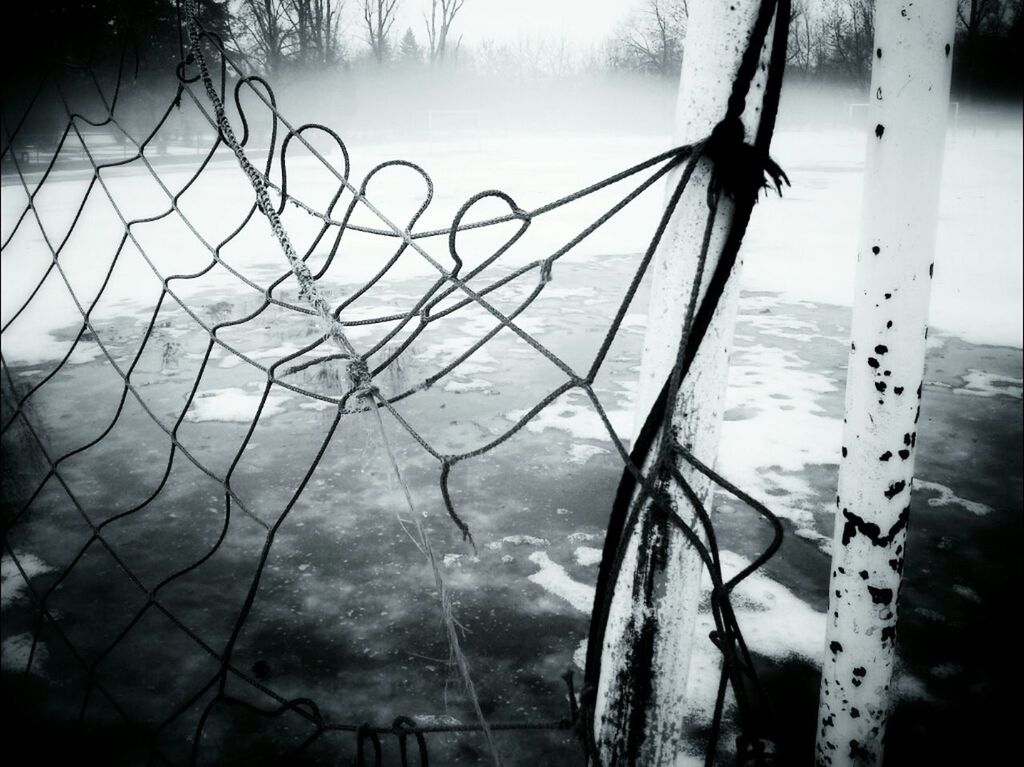 Damaged net on playground in foggy weather