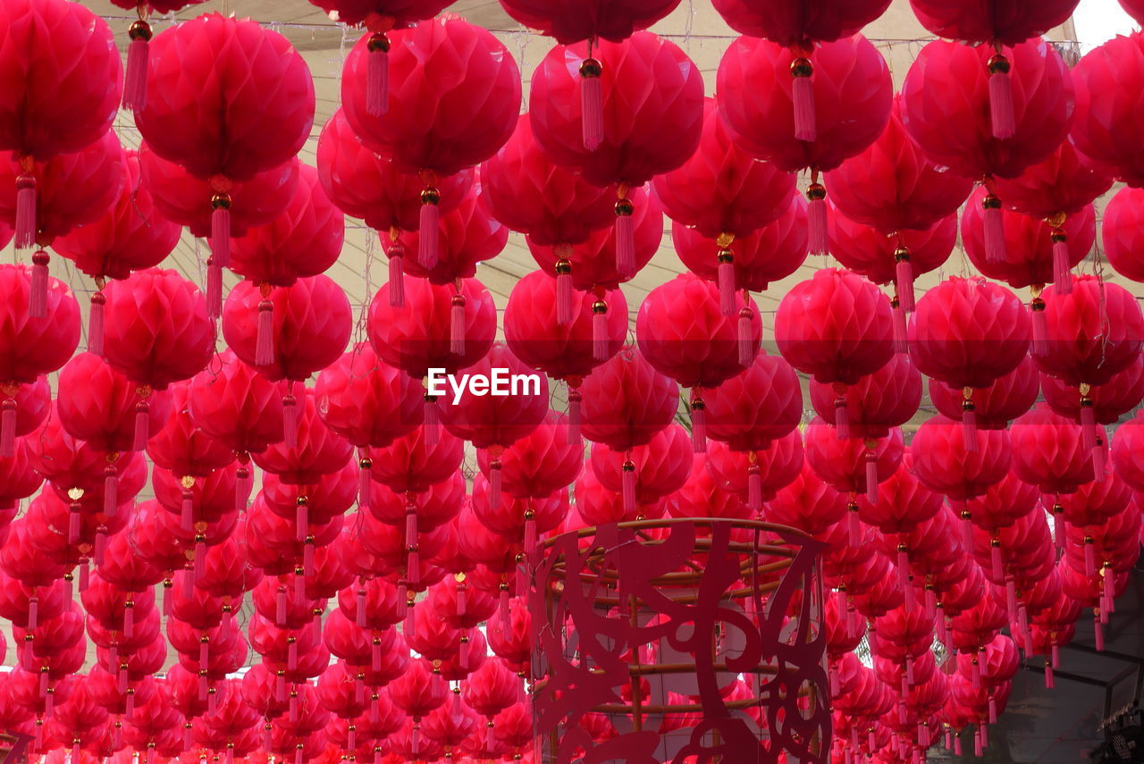 LOW ANGLE VIEW OF RED LANTERNS HANGING ON WALL