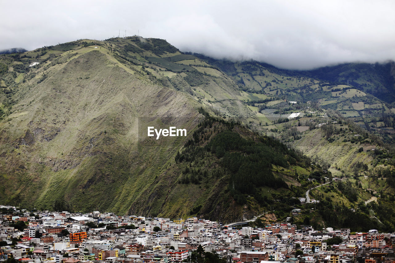 Aerial view of townscape by mountain against sky