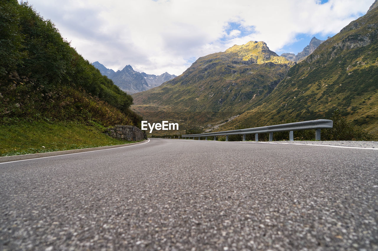 EMPTY ROAD LEADING TOWARDS MOUNTAINS