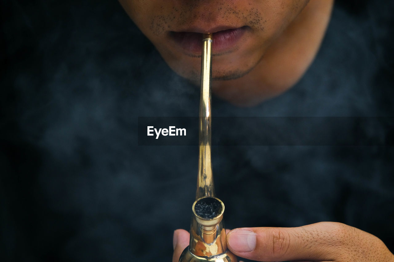 cropped hand of man holding electronic cigarette