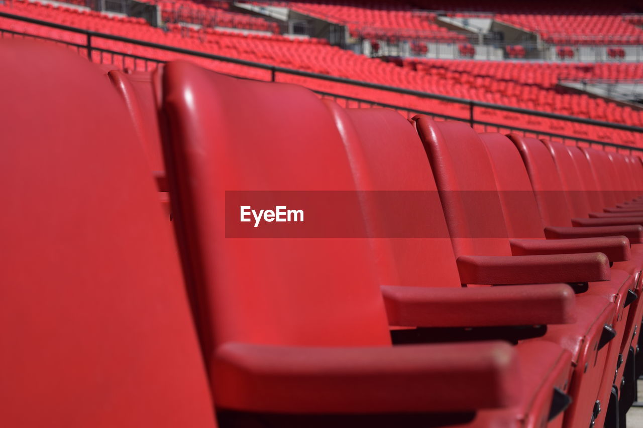 Full frame shot of empty red chairs in stadium