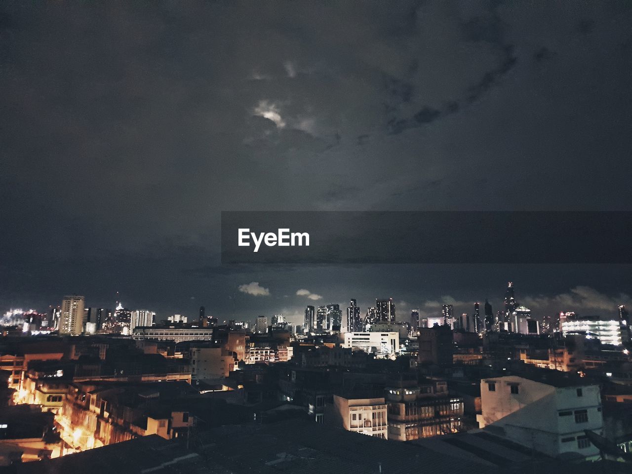 HIGH ANGLE VIEW OF ILLUMINATED CITY BUILDINGS AGAINST SKY