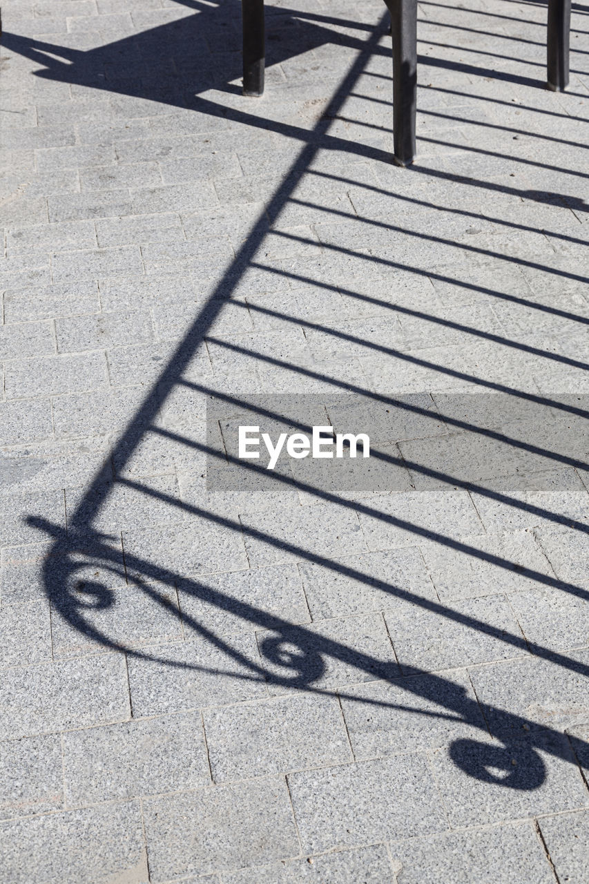 HIGH ANGLE VIEW OF BICYCLE SHADOW ON STREET