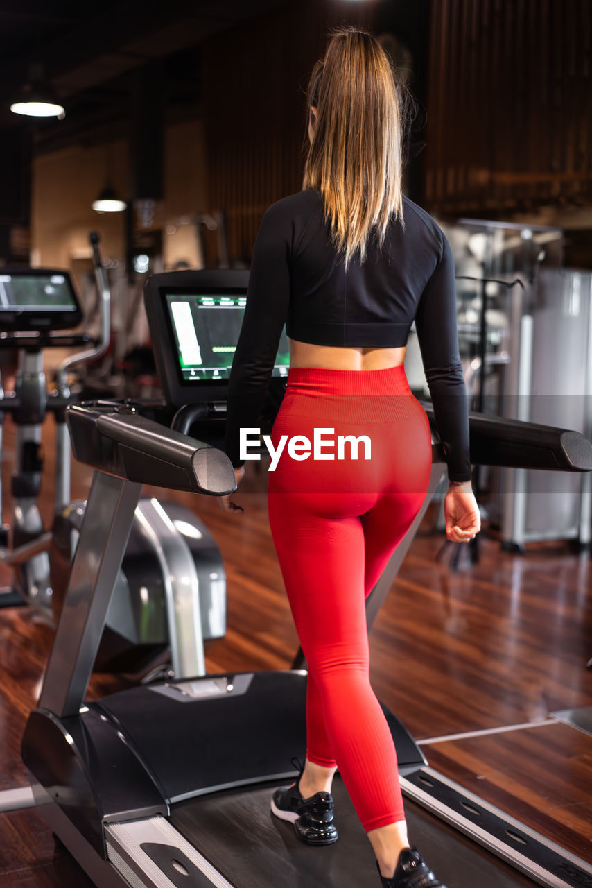 rear view of woman doing yoga in gym