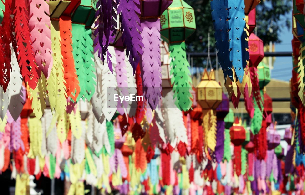 hanging, multi colored, no people, large group of objects, day, tradition, variation, abundance, outdoors, decoration, full frame, retail, belief, built structure, architecture, market, backgrounds, focus on foreground, city, close-up, low angle view, religion