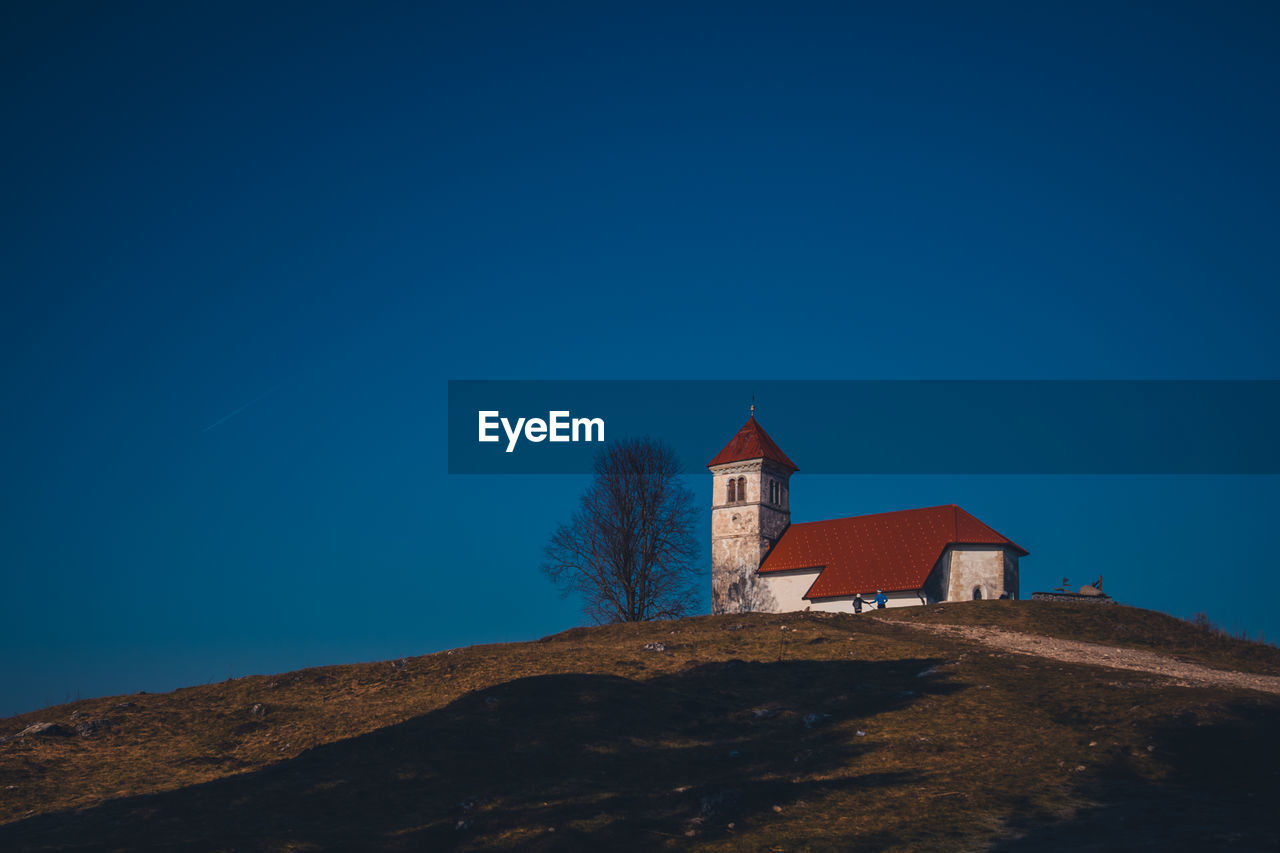 Low angle view of old building against clear blue sky at dusk