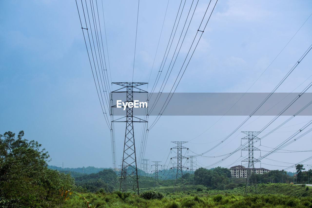 electricity, cable, technology, electricity pylon, power supply, power generation, power line, sky, transmission tower, overhead power line, nature, tower, plant, no people, tree, electrical supply, environment, outdoor structure, cloud, landscape, outdoors, land, outdoor power equipment, day, line, architecture, scenics - nature, built structure, low angle view, blue, communication, transportation, beauty in nature