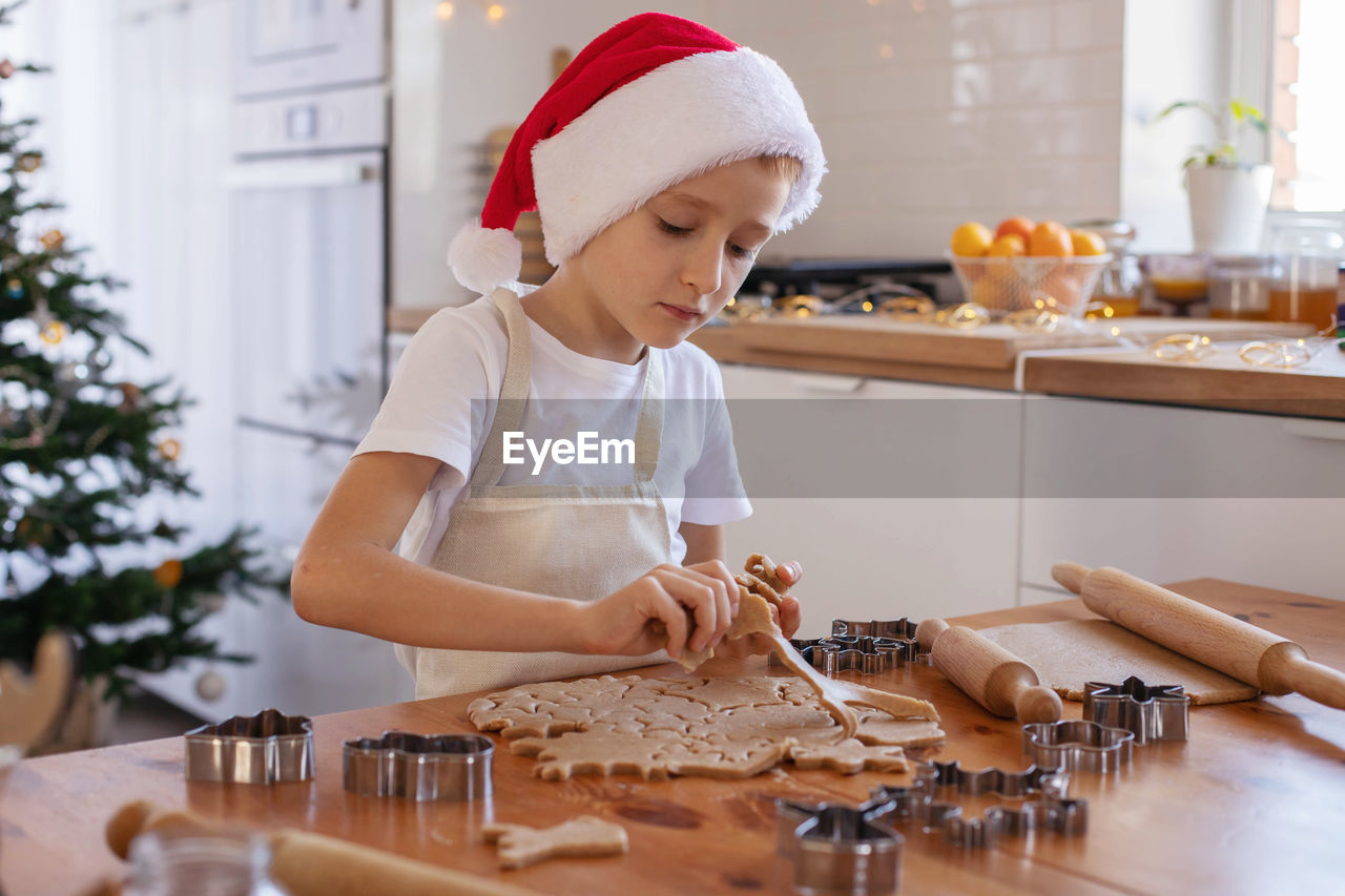 Cute boy making cookies at home