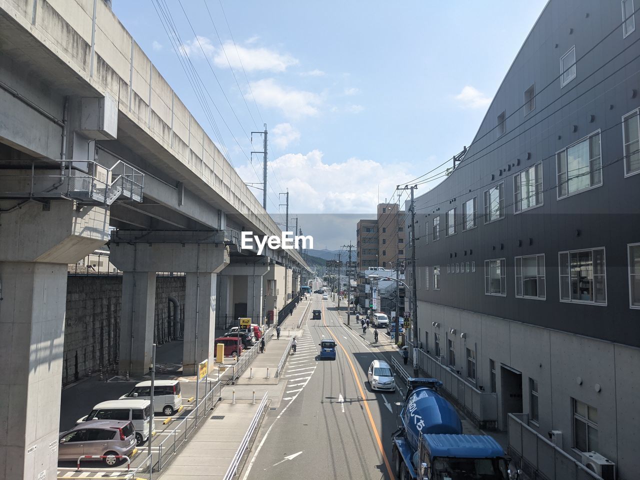 VEHICLES ON ROAD AMIDST BUILDINGS IN CITY