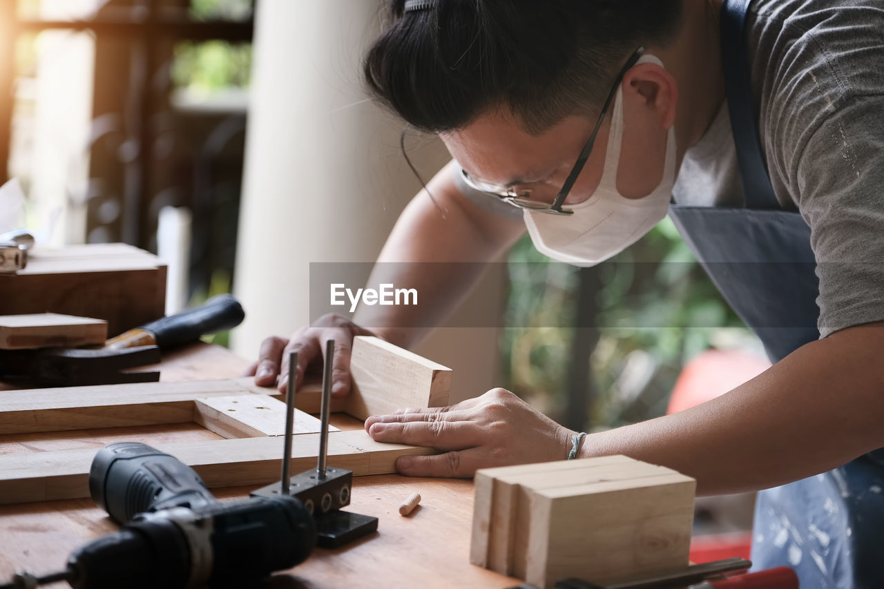 MIDSECTION OF MAN WORKING AT TABLE
