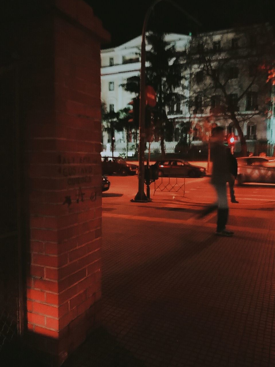 WOMAN STANDING IN ILLUMINATED CITY AT NIGHT