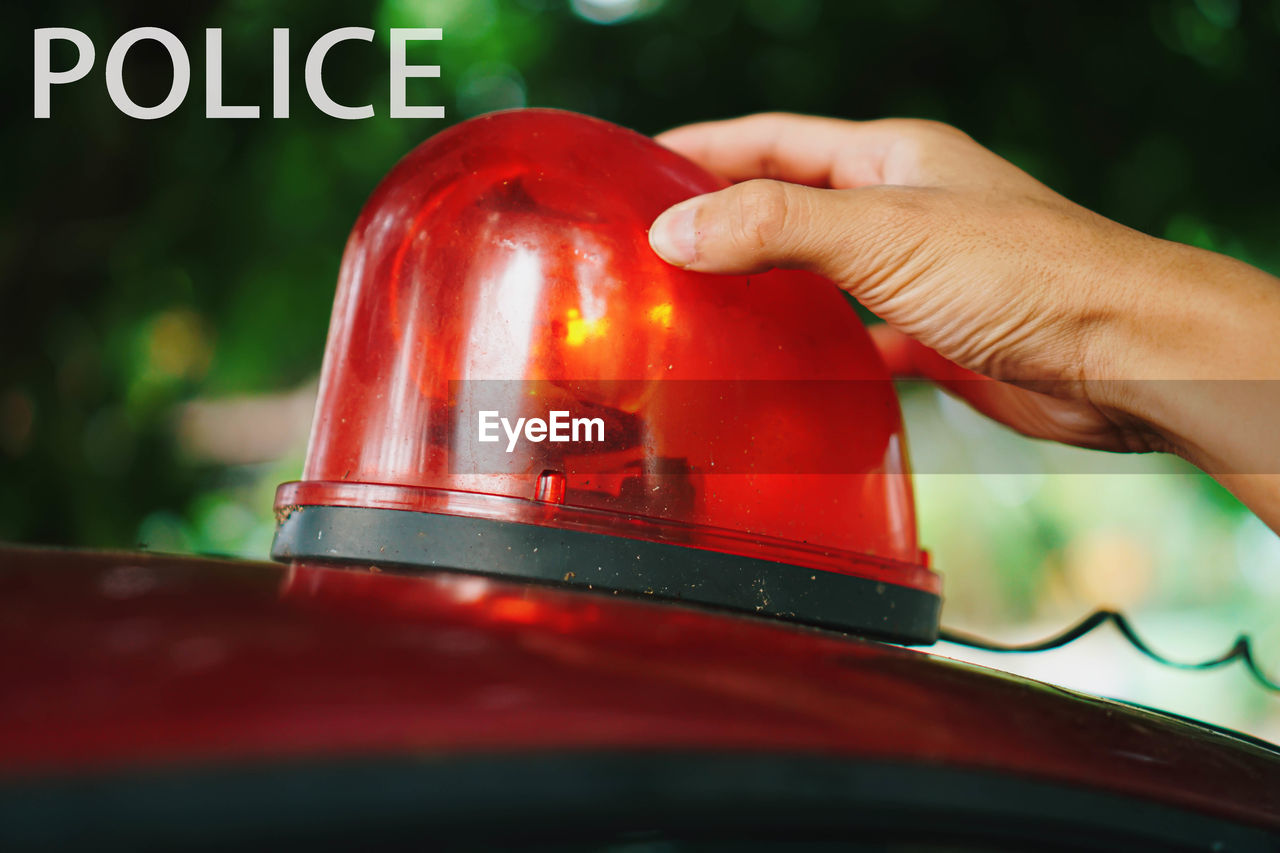 Cropped hand holding police vehicle lighting