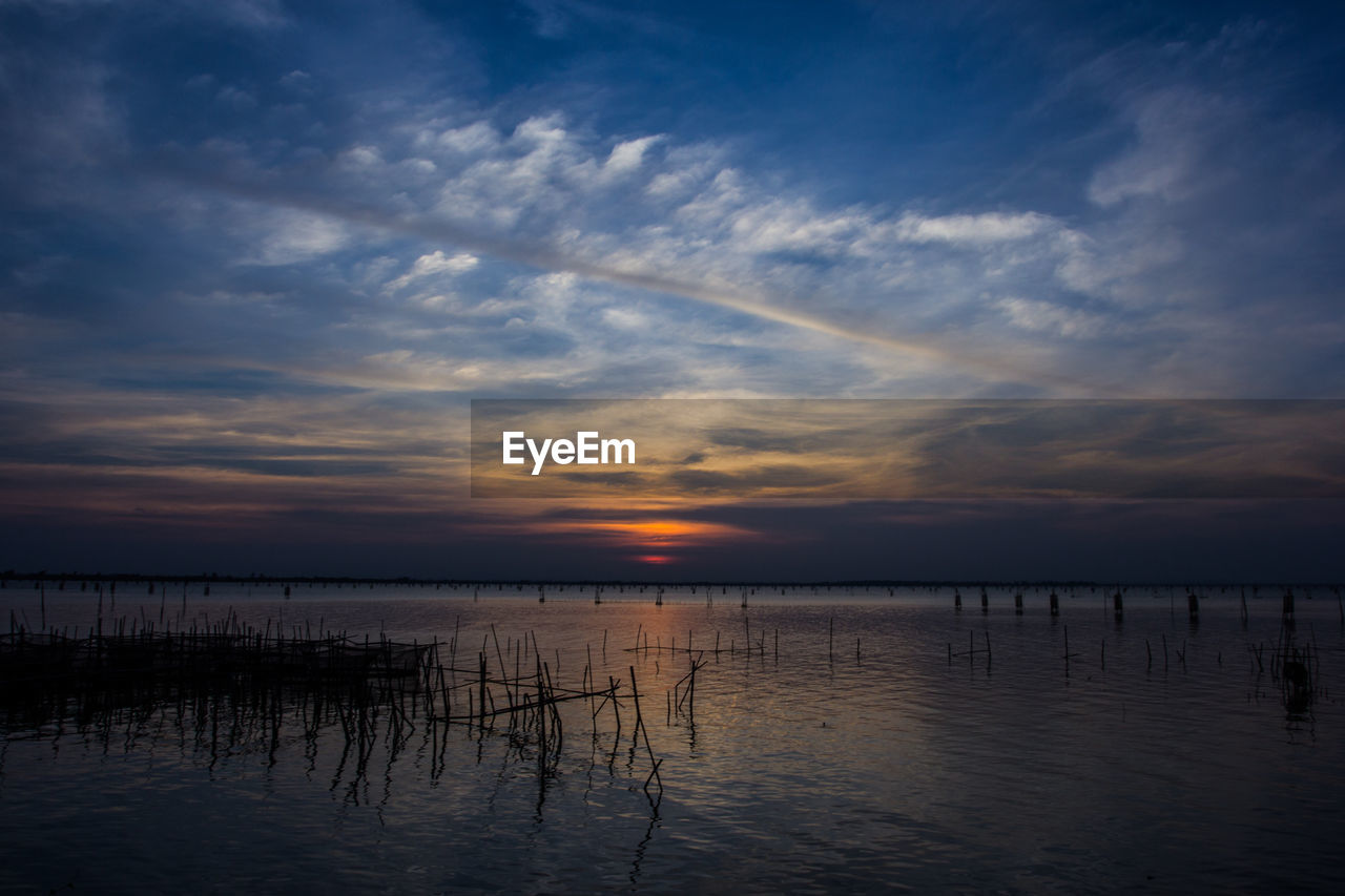 sky, water, cloud, beauty in nature, reflection, scenics - nature, sea, tranquility, nature, sunset, tranquil scene, horizon, dawn, evening, beach, no people, environment, horizon over water, idyllic, dramatic sky, outdoors, land, afterglow, landscape, silhouette, non-urban scene, seascape, blue, sunlight, sun, travel destinations