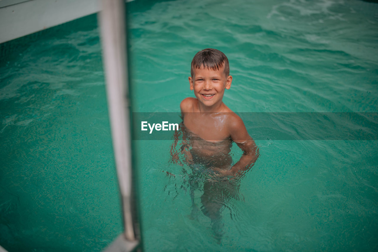 High angle view of shirtless boy in swimming pool
