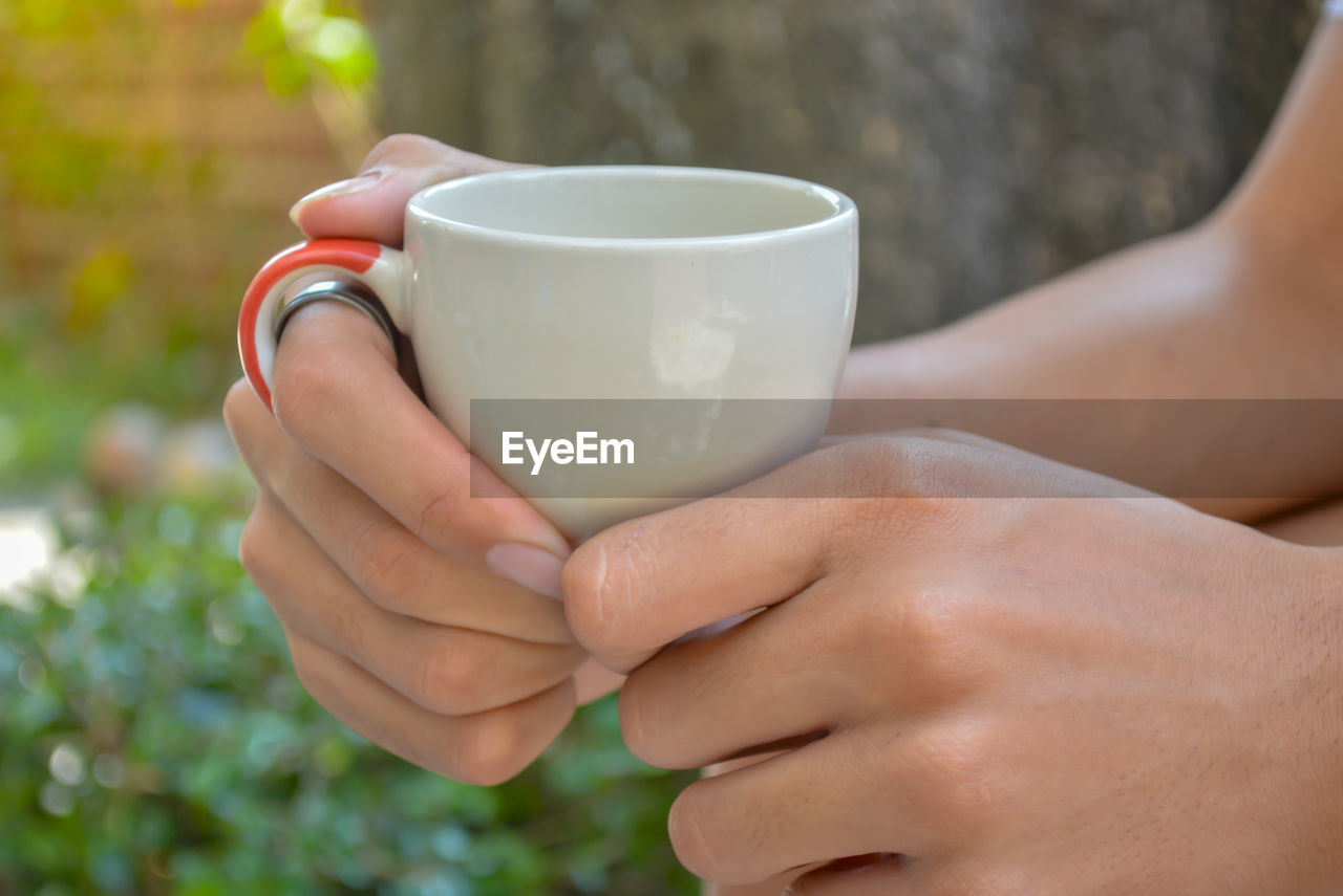 Close-up of hand holding coffee cup