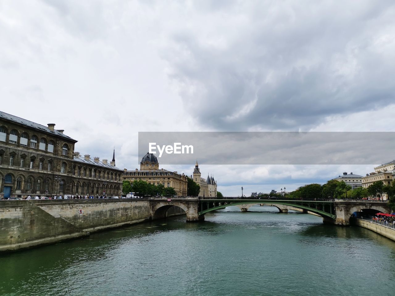 Bridge over river against cloudy sky