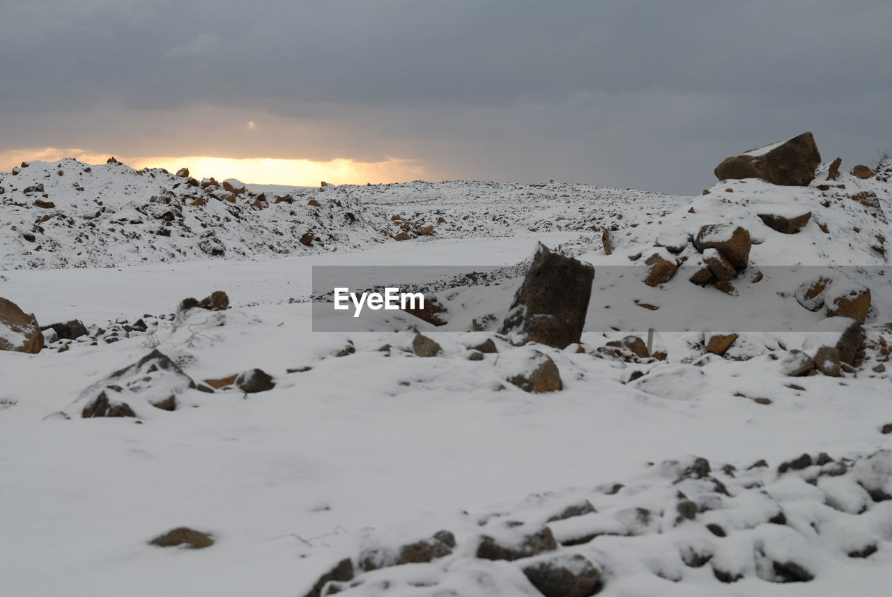 SCENIC VIEW OF SNOW AGAINST SKY AT SUNSET